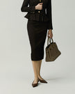 Deep Chocolate pencil skirt on model, lower-body view showing the fitted waist and straight silhouette