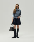 Deep Navy mini skirt on model, full-length front view showing the high-rise waist and pleated A-line shape