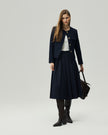 Deep Navy midi skirt on model, full-length front view showing the high-rise waist and pleated A-line silhouette