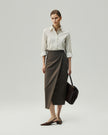 Warm Tea Brown wrap skirt on model, walking side view showing the asymmetric overlap and diagonal hem