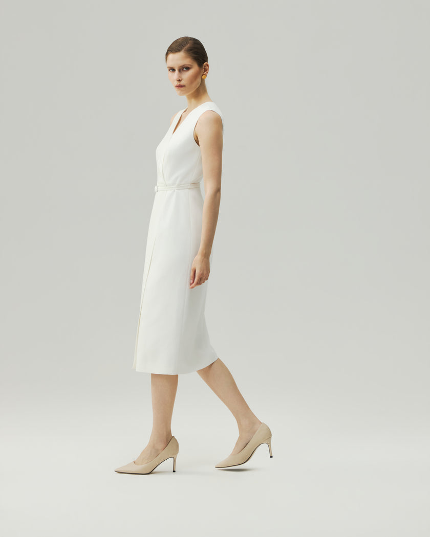 Almond White wrap dress on model, side view showing the sleeveless silhouette and fitted waist