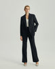 Model wearing Ecole charcoal grey tailored trousers with a matching blazer