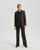 Model wearing Ecole high-rise trousers in ebony with a matching blazer