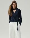Navy reversible blouse on model, front view showing the draped neckline and long sleeves