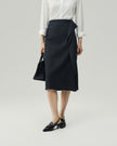 Charcoal Grey asymmetric skirt on model, front view showing the draped overlay and slit