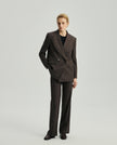 Model wearing the Kai double-breasted blazer in ebony with matching trousers