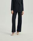 Close-up of Ecole charcoal grey trousers showing the straight-leg silhouette and tailored finish