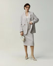 Almond pencil skirt on model, showing the fitted waist and straight silhouette