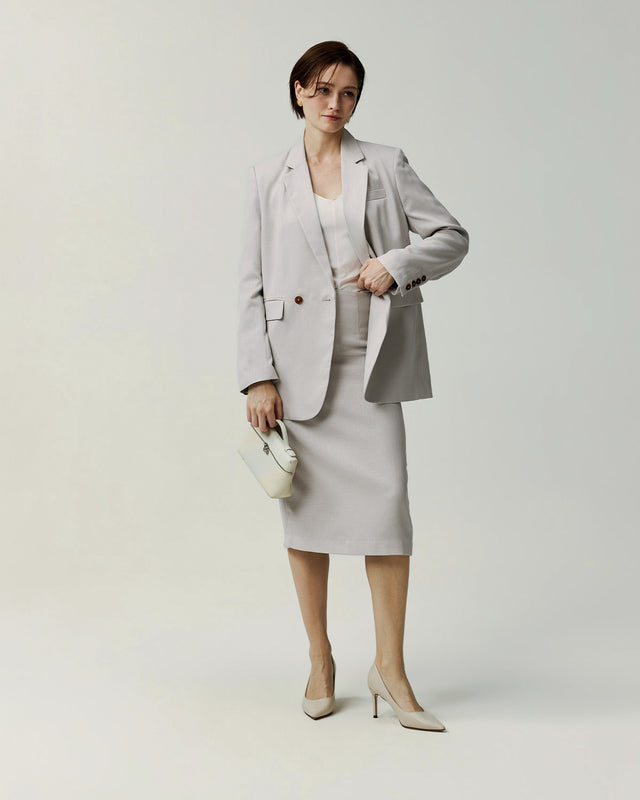 Almond pencil skirt on model, showing the fitted waist and straight silhouette