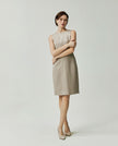 Model wearing the Curie textured apricot dress showing its fitted silhouette and straight skirt