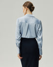 Blouse in Glacier Blue on model, back view showing the clean shoulder line