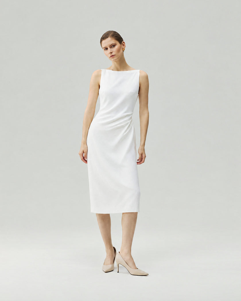 Dress in Almond White on model, highlighting the hand-pinched pleats at the waist