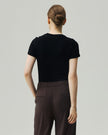 Black fitted T-shirt on model, back view showing the sculpted shoulder seams