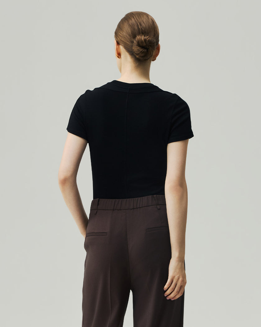 Black fitted T-shirt on model, back view showing the sculpted shoulder seams