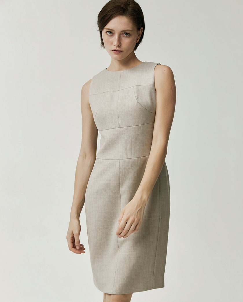 Close-up of the Curie textured apricot dress featuring a round neckline and precision panel seaming