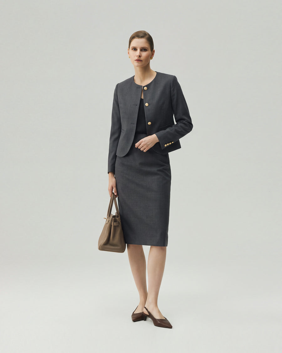 Model wearing the Gabri collarless jacket in charcoal grey with a matching skirt