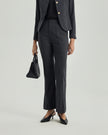Close-up of Gandi charcoal grey trousers showing the fitted waist and subtly flared leg