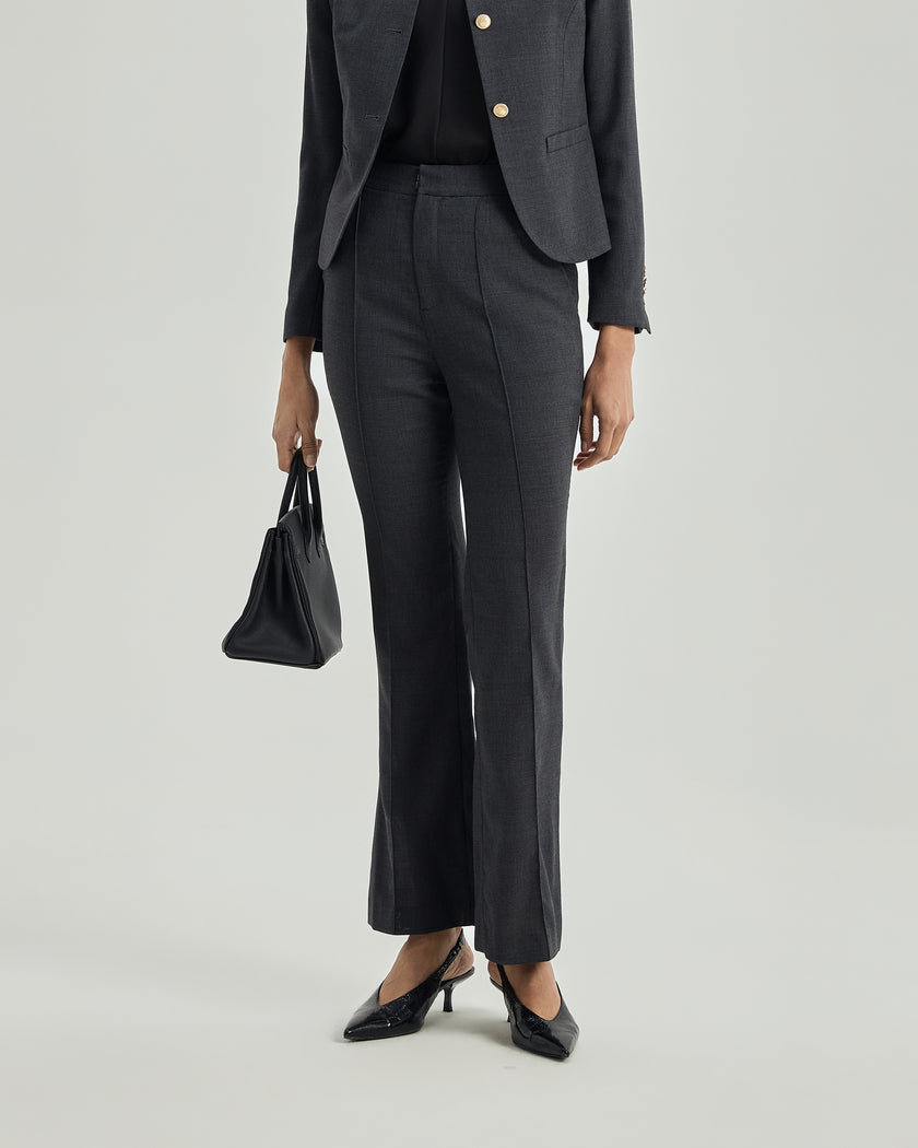 Close-up of Gandi charcoal grey trousers showing the fitted waist and subtly flared leg