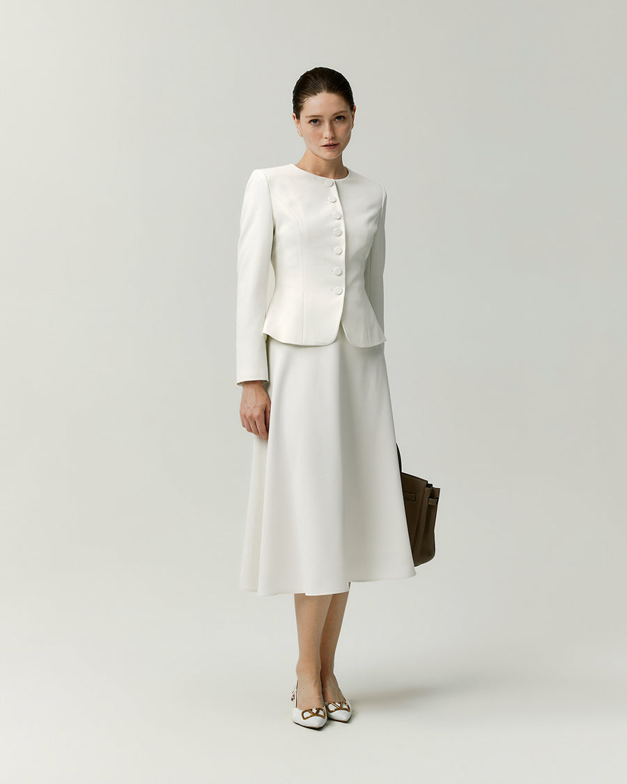 Model wearing the Naya A-line skirt in white with a matching white jacket